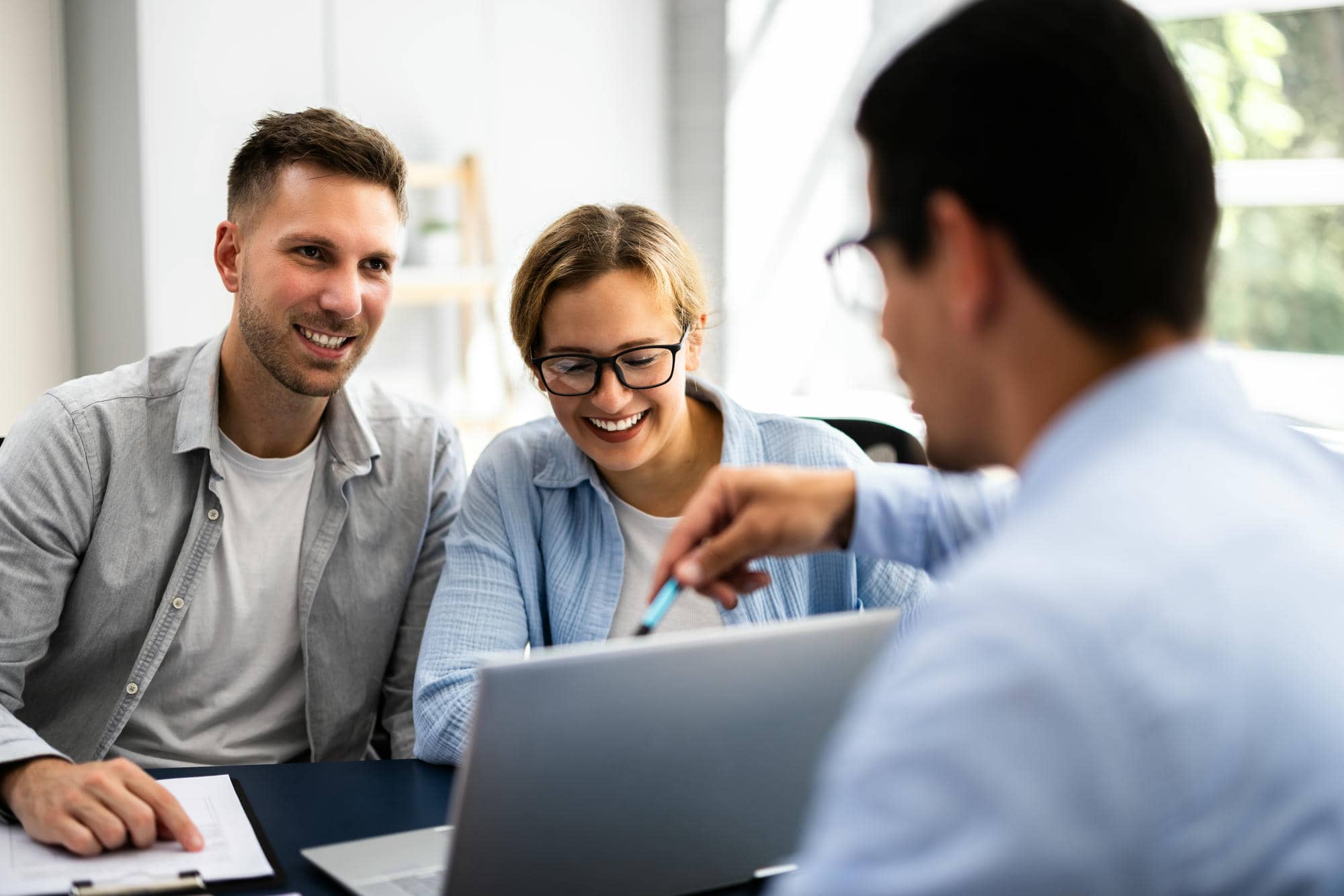 Buchhaltung & Steuerberatung für den Mittelstand_web Drei Personen sitzen um einen Laptop herum und schauen fröhlich und optimistisch. Symbolbild für Steuerberatung im Mittelstand